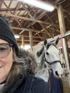 Marianne Fivek smiling and taking a selfie with her horse.